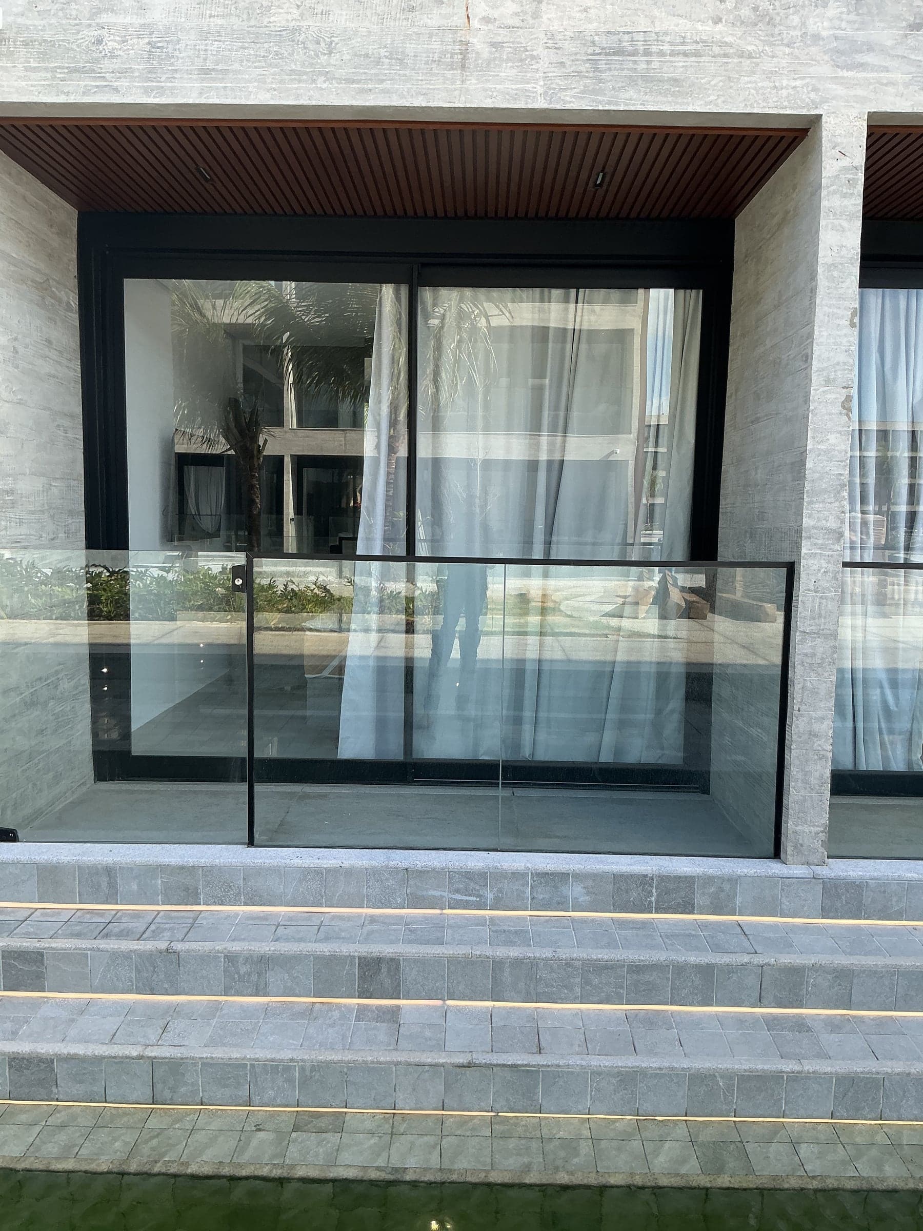 Varanda com porta de correr e guarda-corpo em vidro